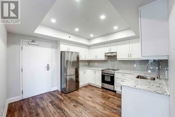 Niagara Falls (Hospital) condo for rent - A modern kitchen with white cabinets and a wooden floor.