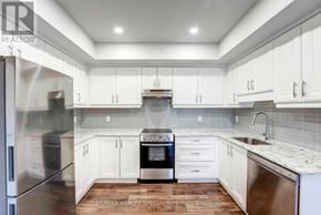 Niagara Falls (Hospital) condo for rent - A modern kitchen with white cabinets and stainless steel appliances.