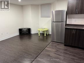 Brampton (Bram West) apartment for rent - A kitchen area with a stainless steel refrigerator, a small yellow stool, and a black flat screen TV.