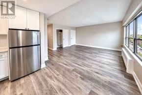 Toronto (South Parkdale) condo for rent - A kitchen with a stainless steel refrigerator and wooden flooring.