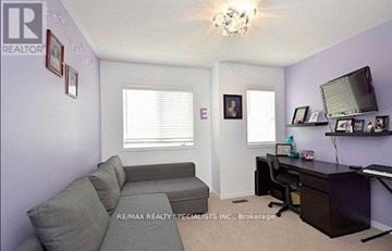 Milton (De Dempsey) townhouse for rent - A living room with a grey couch and a desk with a computer.