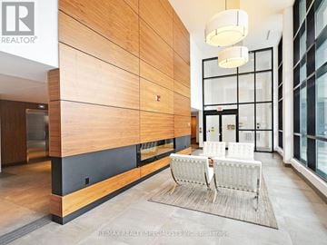 Mississauga (Erin Mills) condo for rent - A modern living room with a white sofa and a wooden wall.