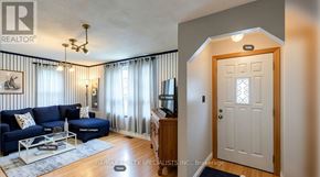 Hamilton (Airport Employment Area) apartment for rent - A living room with a blue couch and a white door.