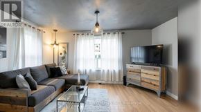 Hamilton (Airport Employment Area) apartment for rent - A modern living room with a grey sofa, a glass coffee table, and a television.