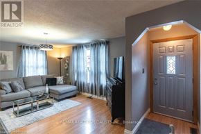 Hamilton (Airport Employment Area) apartment for rent - A living room with a grey couch, a coffee table, a flat screen TV and a grey door.