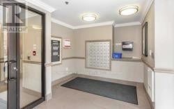 Brampton (Northwest Brampton) condo for rent - A hallway with a glass door and a sign on the wall.