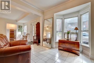 Hamilton (Corktown) apartment for rent - A brown leather couch sits in a spacious living room with white walls and flooring.