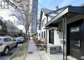 Hamilton (Corktown) apartment for rent - A modern house with a black front door and a stone bench in front.
