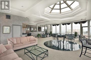 Mississauga (Hurontario) condo for rent - A living room with a glass table and a skylight.