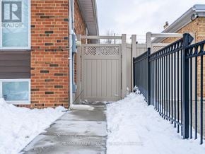 Toronto (Humber Heights) apartment for rent - A house with a brown brick wall and a gate in front of it.