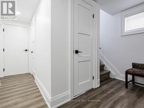 Toronto (Humber Heights) apartment for rent - A white door with a black handle is in a room with wooden flooring.