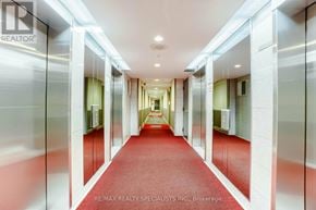 Mississauga (City Centre) condo for rent - A long hallway with a red carpet and white walls.