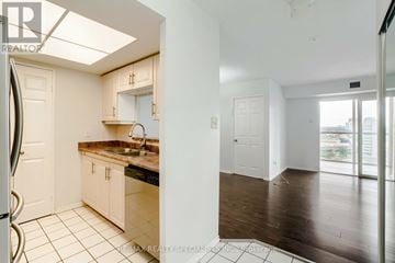 Mississauga (City Centre) condo for rent - A kitchen with white cabinets and a black countertop.