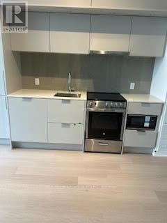 Mississauga (City Centre) townhouse for rent - A modern kitchen with stainless steel appliances and white cabinets.