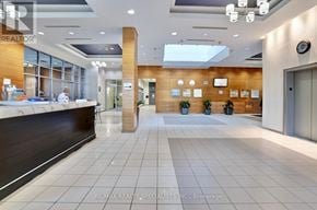 Mississauga (City Centre) condo for rent - A reception area with a desk and a person sitting behind it.