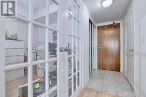 Mississauga (City Centre) condo for rent - A hallway with a brown door and a tiled floor.