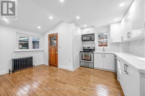 Toronto (Briar Hill-Belgravia) apartment for rent - A spacious kitchen with white cabinets and a wooden door.