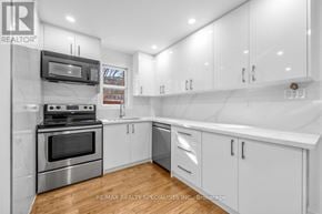 Toronto (Briar Hill-Belgravia) apartment for rent - A modern kitchen with white cabinets and stainless steel appliances.