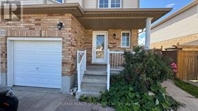 Kitchener apartment for rent - A house with a white garage door and a brick wall.
