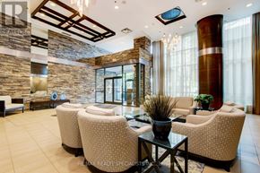 Mississauga (Port Credit) condo for rent - A living room with a stone wall and a glass table.