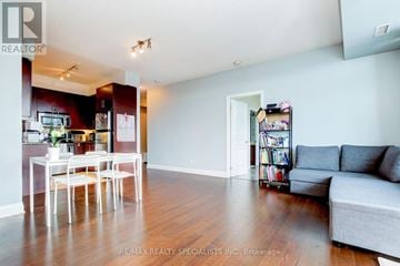 Mississauga (Port Credit) condo for rent - A living room with a grey couch and a dining table with chairs.