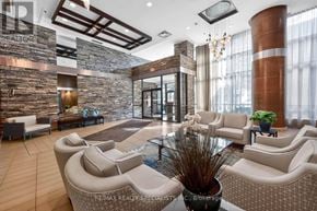 Mississauga (Port Credit) condo for rent - A modern waiting room with white furniture and a stone wall.