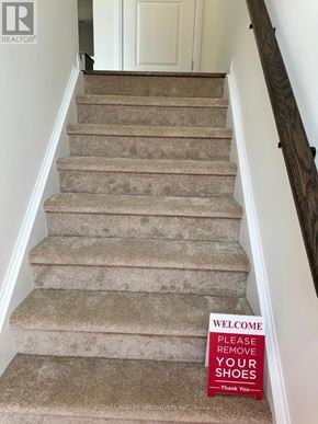 Brantford townhouse for rent - A sign on a staircase says "Please remove your shoes.".