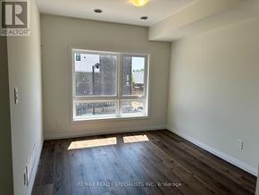 Brantford townhouse for rent - A room with a window showing a view of a street and houses.