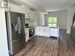 Brantford townhouse for rent - A kitchen with a stainless steel refrigerator and wooden floors.