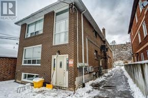 Toronto (Rockcliffe-Smythe) multi-family for rent - A snow-covered residential street with a brick house on the left.