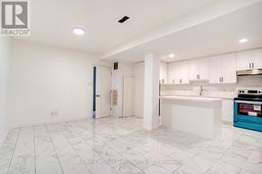 Toronto (Rockcliffe-Smythe) multi-family for rent - A spacious kitchen with white cabinets and a blue oven.