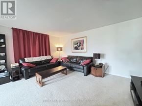 Milton (Ha Harrison) townhouse for rent - A living room with a black couch and a red curtain.