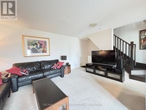 Milton (Ha Harrison) townhouse for rent - A living room with a black leather couch and a television.