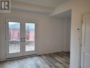 Brant (Paris) townhouse for rent - A room with a slanted ceiling and a view of a construction site through the glass doors.