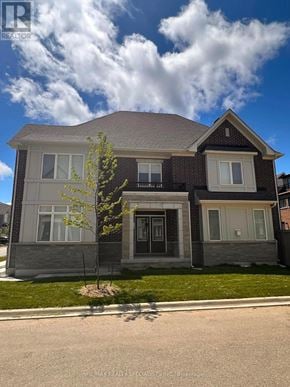 Brampton (Northwest Brampton) apartment for rent - A house with a grey and brown exterior is shown with a blue sky and clouds in the background.