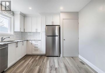 Kitchener apartment for rent - A kitchen with white cabinets and a stainless steel refrigerator.