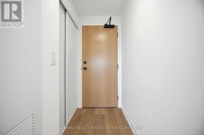 Brantford condo for rent - A hallway with a wooden door and a white wall.