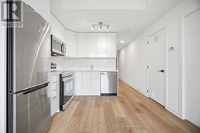 Brantford condo for rent - A modern kitchen with a refrigerator, microwave, and dishwasher.