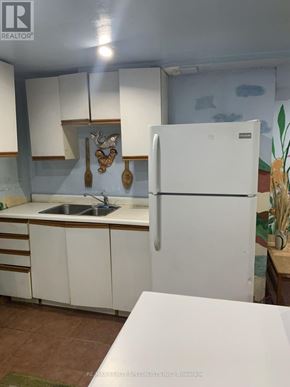 Richmond Hill (Devonsleigh) apartment for rent - A white refrigerator stands in a kitchen with white cabinets and a white countertop.