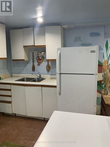 Richmond Hill (Devonsleigh) apartment for rent - A white refrigerator stands in a kitchen with white cabinets and a white countertop.