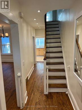 Toronto (Humewood-Cedarvale) apartment for rent - A staircase with a wooden handrail and steps leading to a landing with a window.