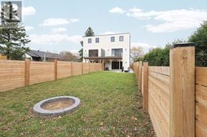Mississauga (Lakeview) apartment for rent - A modern house with a wooden fence and a fire pit in the yard.