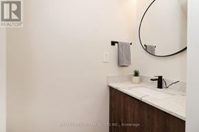 Mississauga (Lakeview) apartment for rent - A bathroom with a marble countertop and a round mirror.
