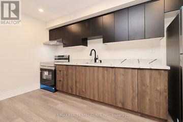 Mississauga (Lakeview) apartment for rent - A modern kitchen with wooden cabinets and a white countertop.