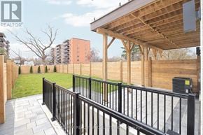 Mississauga (Lakeview) apartment for rent - A wooden deck with a black railing and a building in the background.
