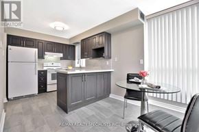 Toronto (Beechborough-Greenbrook) condo for rent - A modern kitchen with a glass table and black chairs.