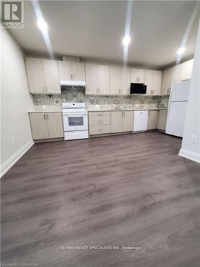 Hamilton (Beasley) condo for rent - A kitchen with white appliances and wooden cabinets.