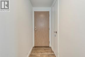 Toronto (Waterfront Communities) condo for rent - A wooden door is in the middle of a white hallway.