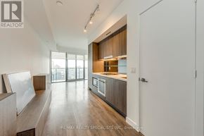 Toronto (Waterfront Communities) condo for rent - A modern kitchen with wooden cabinets and a large island.