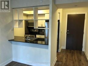 Toronto (Etobicoke West Mall) condo for rent - A kitchen with white walls and a black countertop.